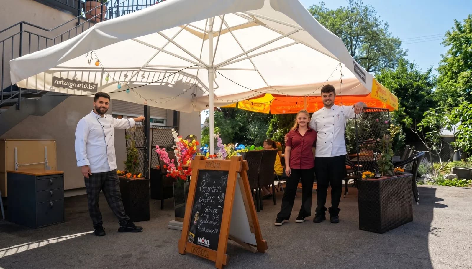 Das Team im Garten von Spice and Salsa unter dem grossen Sonnenschirm